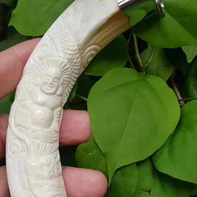 Mặt dây chuyền Nam Nanh Chạm Phật Di Lặc Giả Ngà hay gọi Xương mỹ nghệ màu trắng Mặt dây chạm hình Phật Di Lặc đã bọc khoen inox Nam đeo với sợi dây chuyền của mình đẹp ạ 